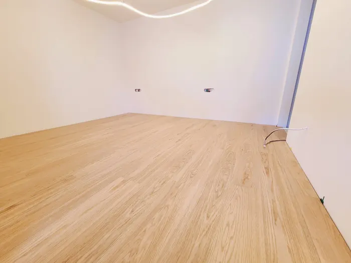 Pièce terminée avec parquet clair posé et murs peints